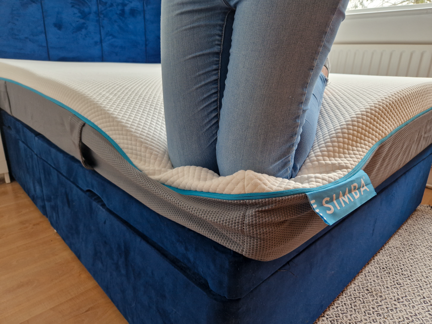 Kneeling on the edge of the Simbatex Foam mattress